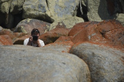 Hayden peeking over the rocks to take a photo of me